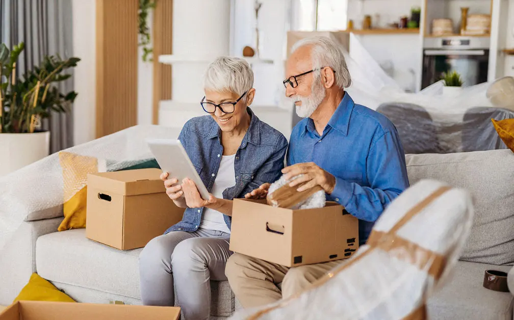 senior couple unpacking moving boxes