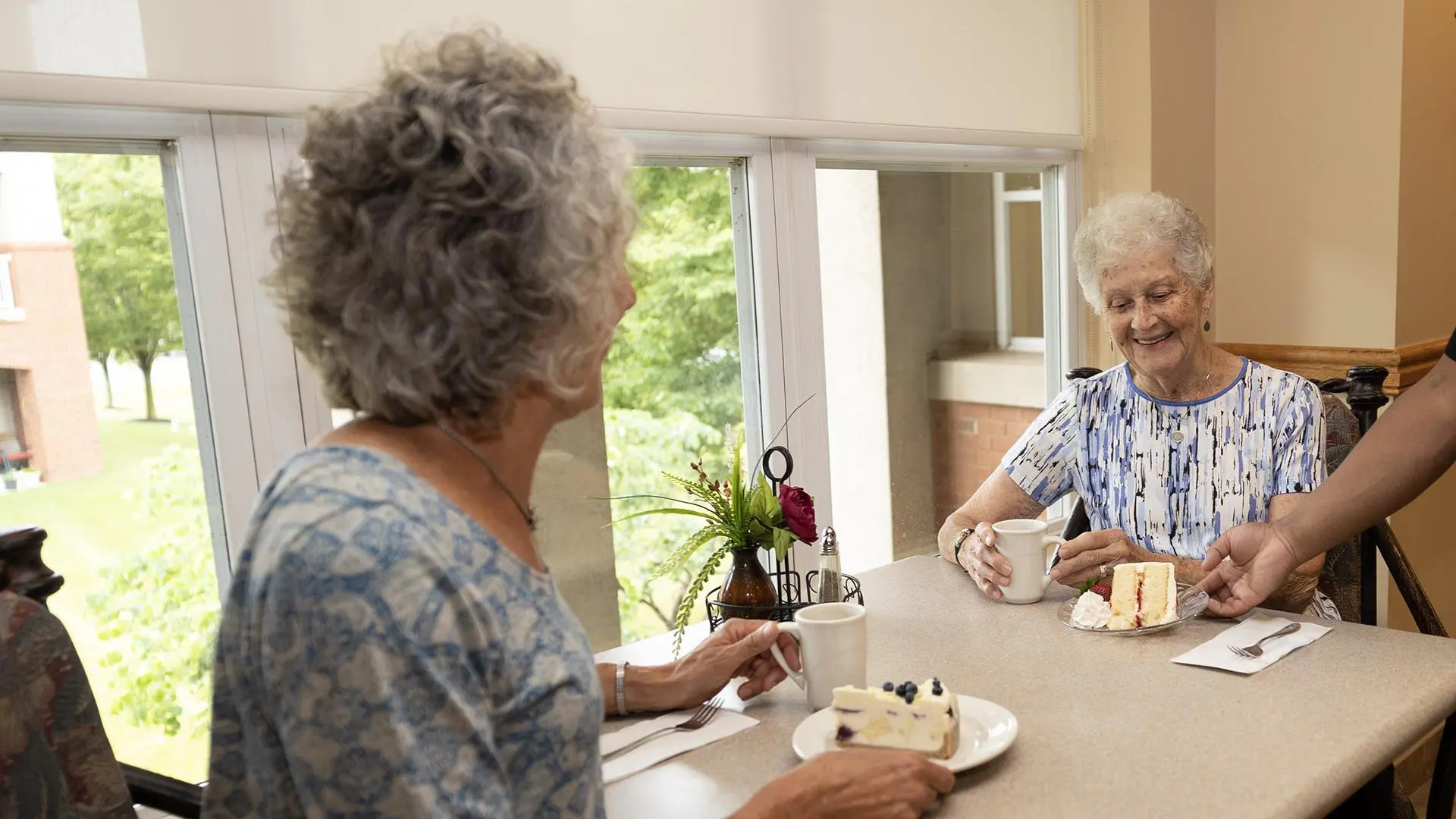 two senior women having cake at peter becker community