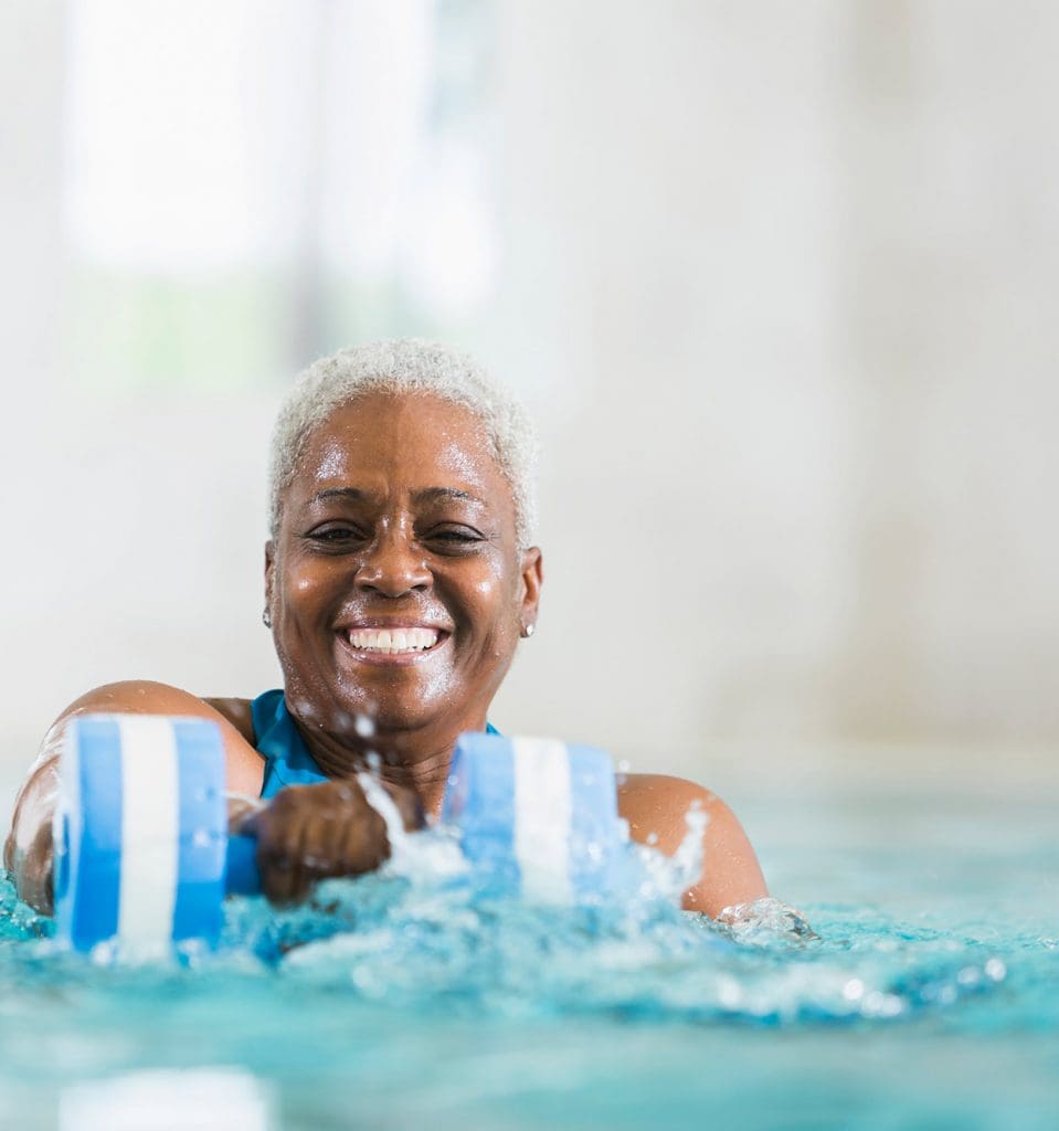 Senior-Aged Woman Exercising in Pool Senior-Aged Woman Exercising in Pool