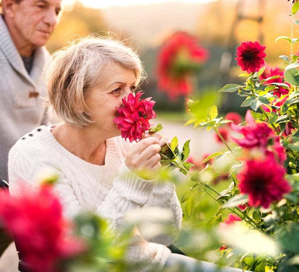 Senior-Aged Woman Smelling Flowers