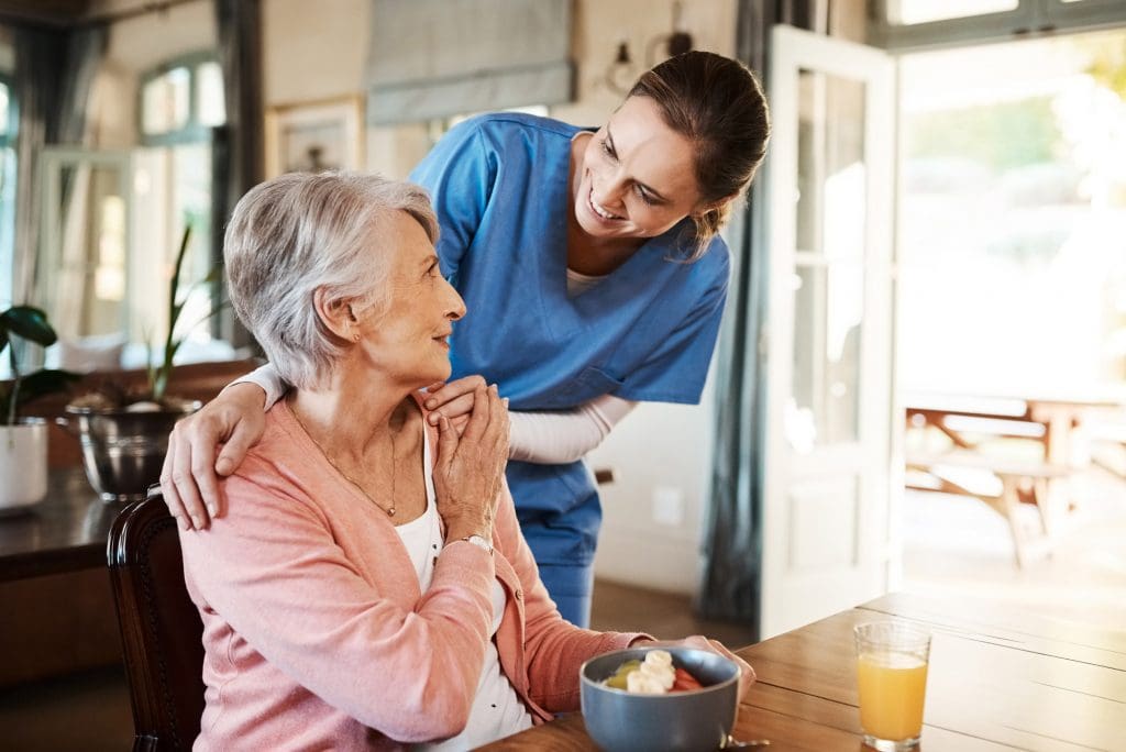 Peter Becker Community caregiver checking resident who is eating breakfast