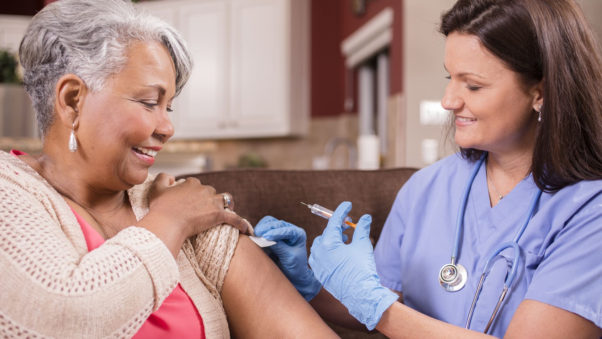 nurse vaccinating senior woman