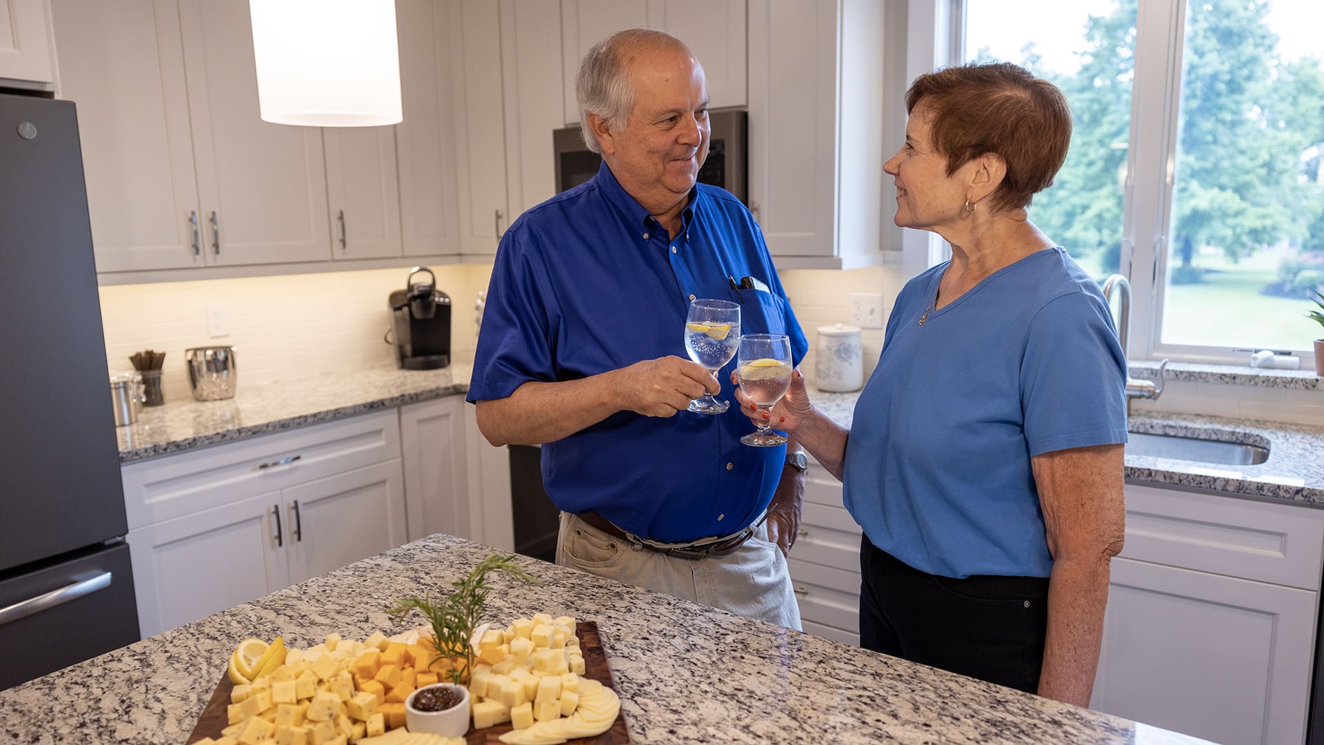 senior couple having a cheese plate in their kitchen
