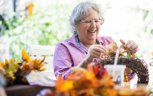 woman making fall crafts outside