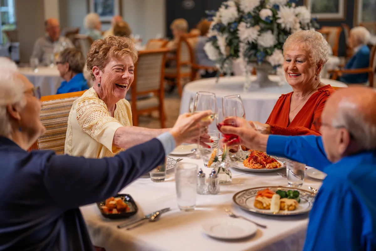 seniors-at-dinner-toast Senior Aged Woman Smiling at Male Companion