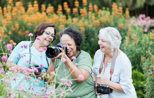 Three elderly woman doing plant photography as a part of great creativity exercises for seniors at Peter Becker Community.